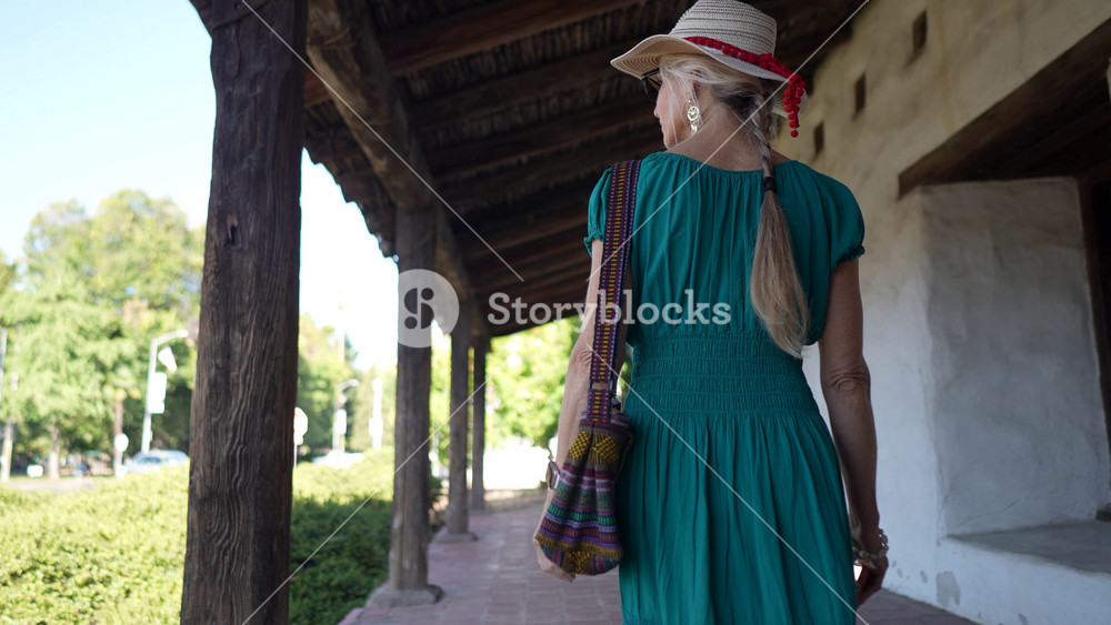 A mature woman smiles while walking through the historic Mission church in Sonoma, California, enjoying her visit to the site