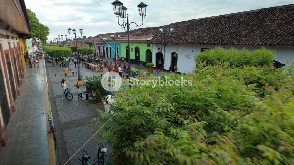 Streets in colonial Granada Nicaragua show people enjoying local culture and dining at outdoor cafes near vibrant buildings
