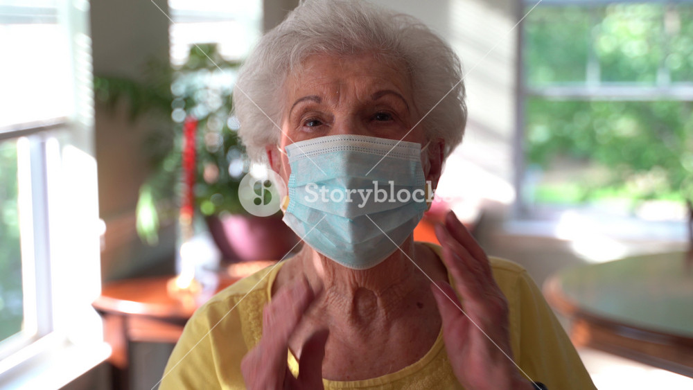 Closeup portrait of elderly woman putting on medical face mask protection. Quarantine coronavirus covid-19 for old people. Retirement Health at Risk, granny in mask