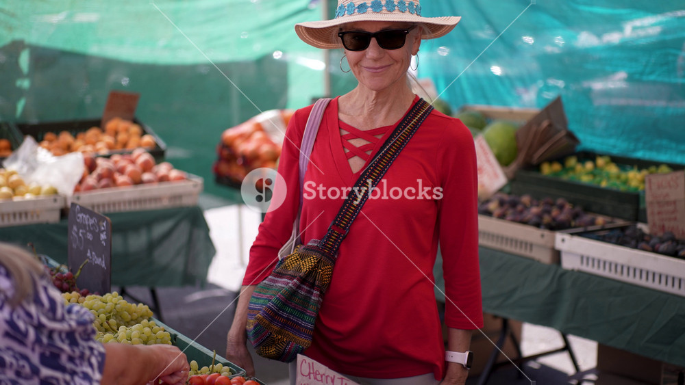 A woman enjoys for fruits and vegetables at the farmers market in Sonoma, California, on a bright and sunny morning