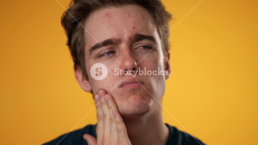 Closeup slow motion portrait of sad, unhappy, angry, upset, frustrated, young man 20s isolated on yellow color background in studio. Sincere emotions lifestyle concept