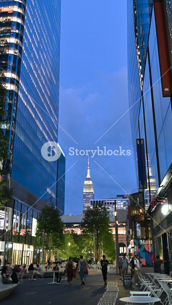 New York City,USA,August 14, 2024. Stunning vertical footage of the blue hour. From the High Line we see the unmistakable silhouette of the Empire State Building. The pan movement shows people walking