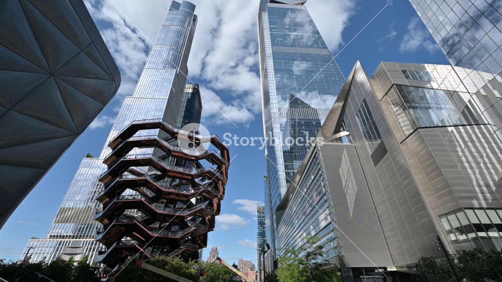 New York City, USA, August 20, 2024. The modern structure of the Vessel, a new landmark in the city. People walking in the public space between the skyscrapers. Beautiful summer day.