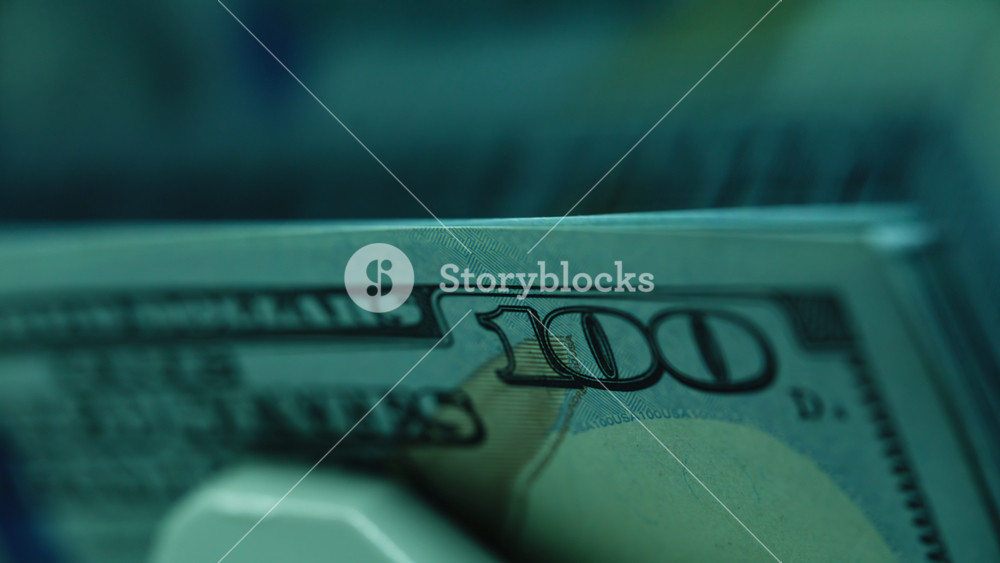Closeup cash paper money calculating automatic bank equipment. Currency counting machine flipping 100 dollar banknotes. USA federal fed
