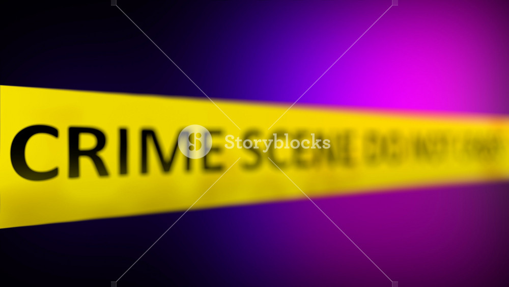 A yellow crime scene tape with the words CRIME SCENE DO NOT CROSS written on it in front of Police Red And Blue Flasher Siren effect. Shallow depth of field.