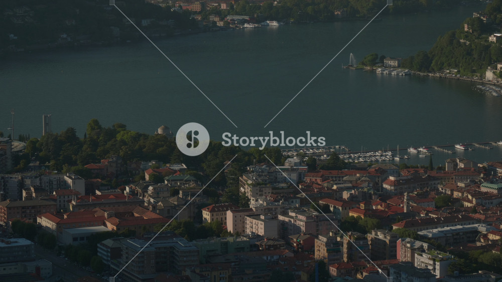 The city of Como in northern Italy seen from above. The historic center stretches at the foot of the hill with its maze of ancient streets, elegant squares, and the unmistakable profile of the Duomo.