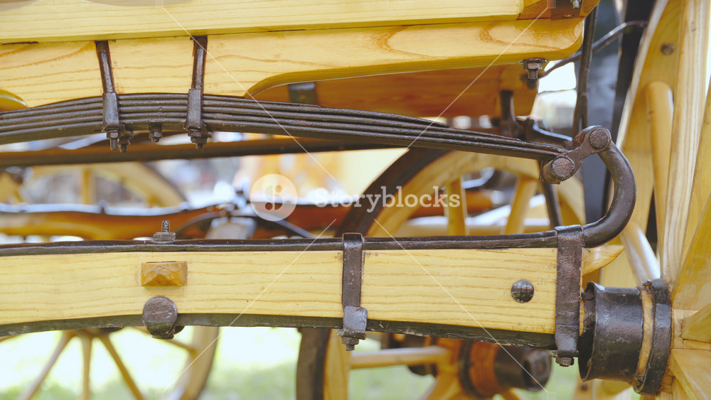 Retro carriage made from wood and handmade iron close-up slide 4K. Dolly shot of rear carriage wheel axis in focus stopping at the side wooden wheel.