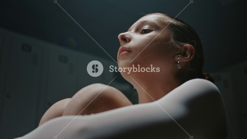 Experiencing Crisis, Sports Burnout After Failing to Reach Podium. Sitting in Empty Locker Room, Girl Reflects on High Expectations. Intense