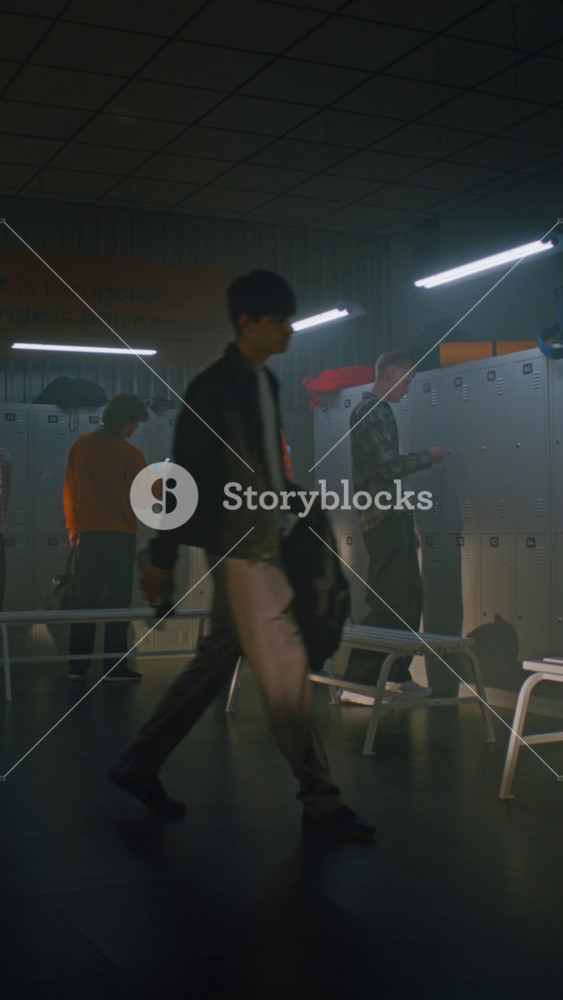 Large Group of Diverse Teenage Boys Enters Modern Sports Locker Room, Talking and Staring at Heading to Metal Lockers. Lifestyle Youth
