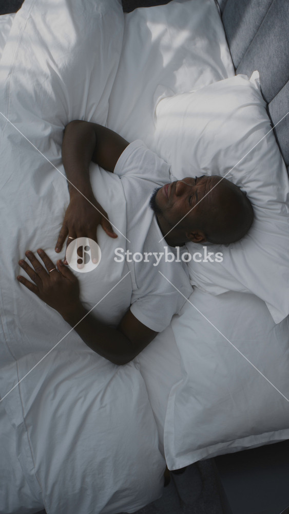 Adult Man Picks Up Phone Immediately After Waking Up Checks Messengers. African American Man Wakes Up, Goes Online. Connected Lifestyle