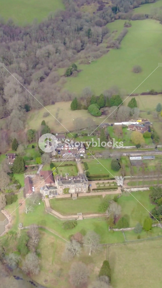 country house overfly england english helicopter luxury estate situated green british countryside aerial view birds eye above historic buildings elegant flyover uk