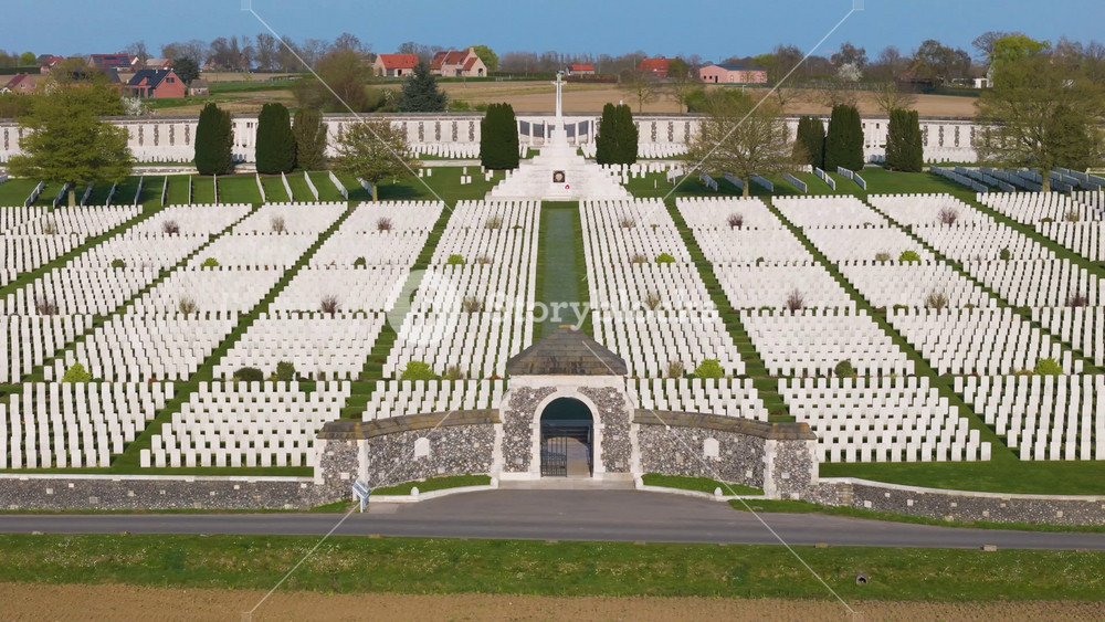 war cemetery tyne cot aerial panorama aligned rows white wwi gravestones towering cross of sacrifice curved memorial wall farmland zonnebeke belgium flanders remembrance lest we forget 1917 aerial