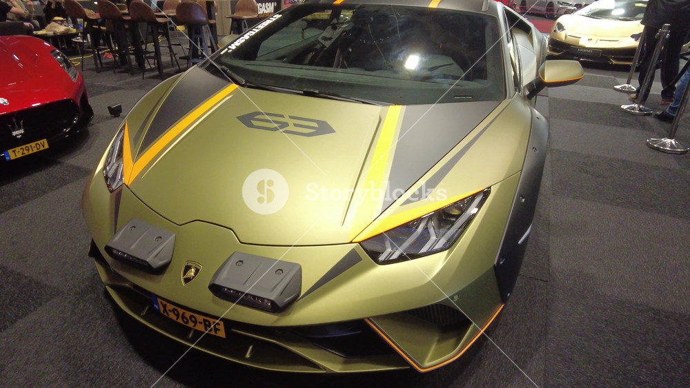 lamborghini huracan sterrato grey gold brown supercar bonnet upwards brussels auto show 2024 motor event exhibition front panning shot yellow italian