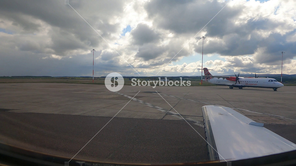 airplane window taxiing next to loganair atr passenger parked inverness airport uk view logan air cessna citation mustang private jet