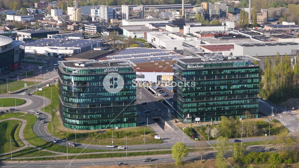 attentia hudson office towers ghent aerial focused view twin curved glass towers pwc branding looping roads urban development project modern infrastructure Flemish region
