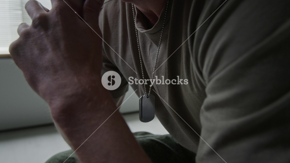 Caucasian male veteran wearing dog tags crying and covering face in emotional distress. Footage for mental health awareness campaigns and veteran support services