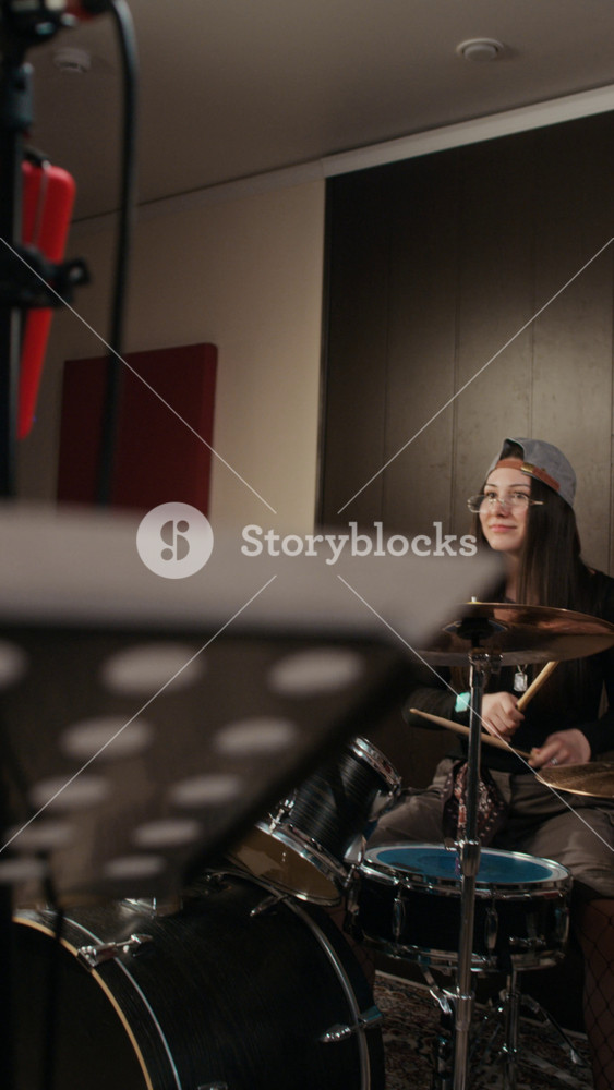 Vertical video of Caucasian teenager playing drums and African American teenager singing into microphone during rehearsal. Footage is perfect for youth music education commercials