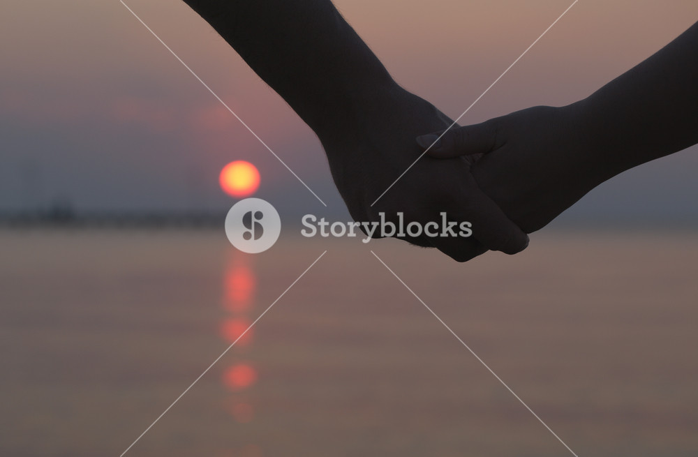 Couple holding hands at sunset Royalty-Free Stock Photo SBI-300934966 ...