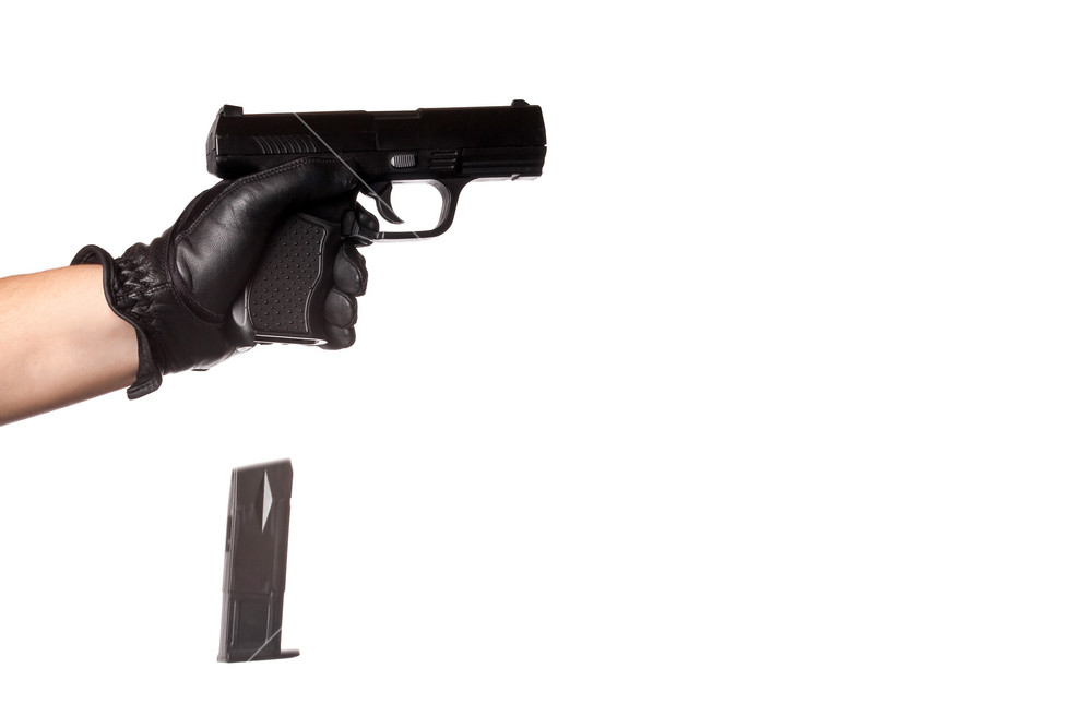 Falling Reloading A man reloading a weapon drops the clip from a black handgun. Slight ...