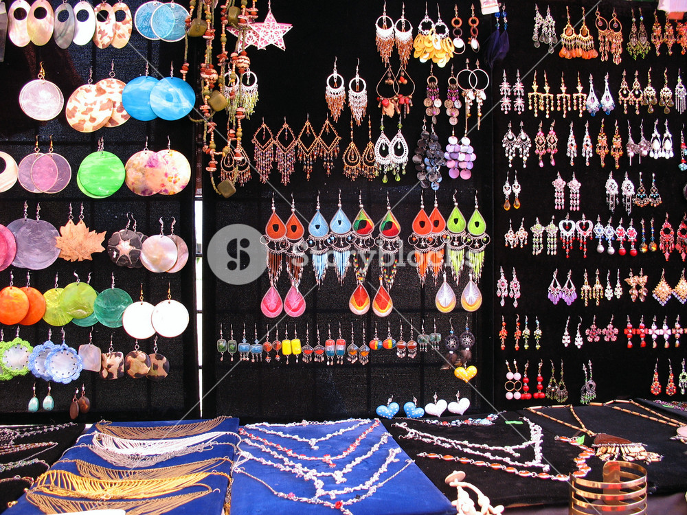 A very colorful assortment of jewelry on display.  Many of these are isolated nicely over black, and can be cut out very easily.