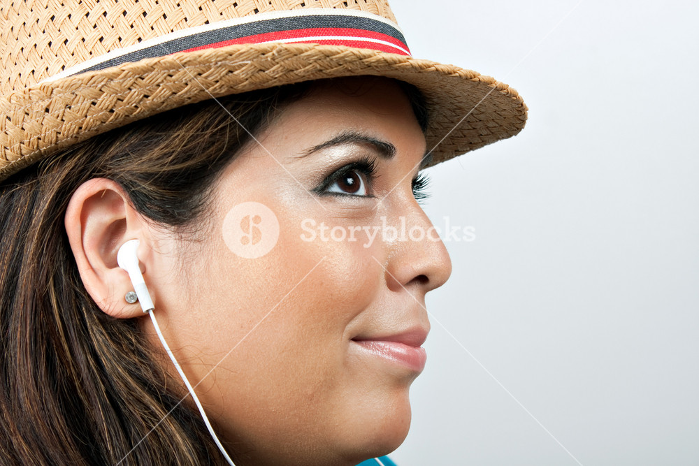A woman enjoying music with stereo earbud headphones.