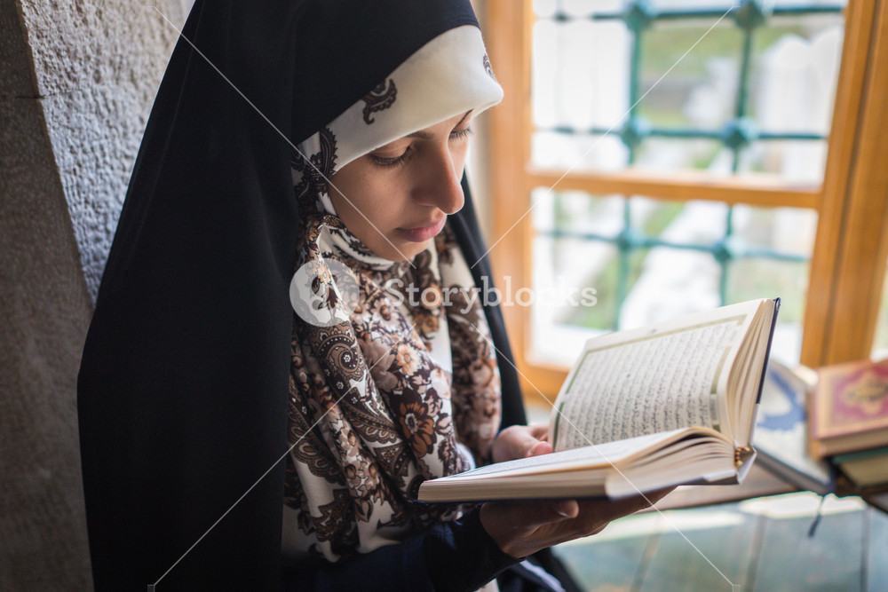 Muslim woman reading the holy book in a mosque Royalty-Free Stock Photo ...