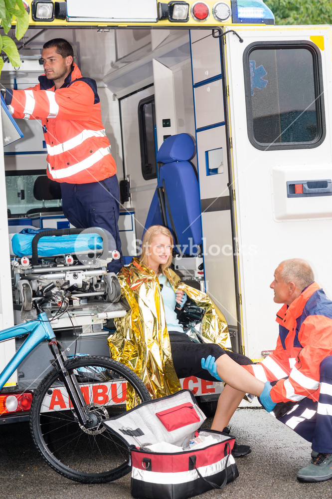 Emergency paramedics with woman bike accident in ambulance help injury ...