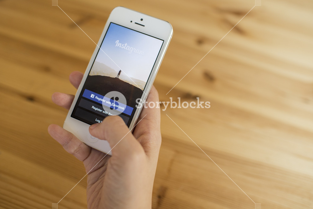 CHIANG MAI, THAILAND - SEPTEMBER 07, 2014: A girl trying to log in Instagram application using Apple iPhone 5. Instagram is largest and most popular photograph social networking site in the world.