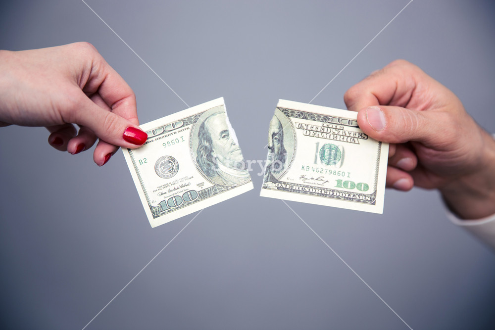Concept image of a female and male hand dividing money Royalty-Free ...