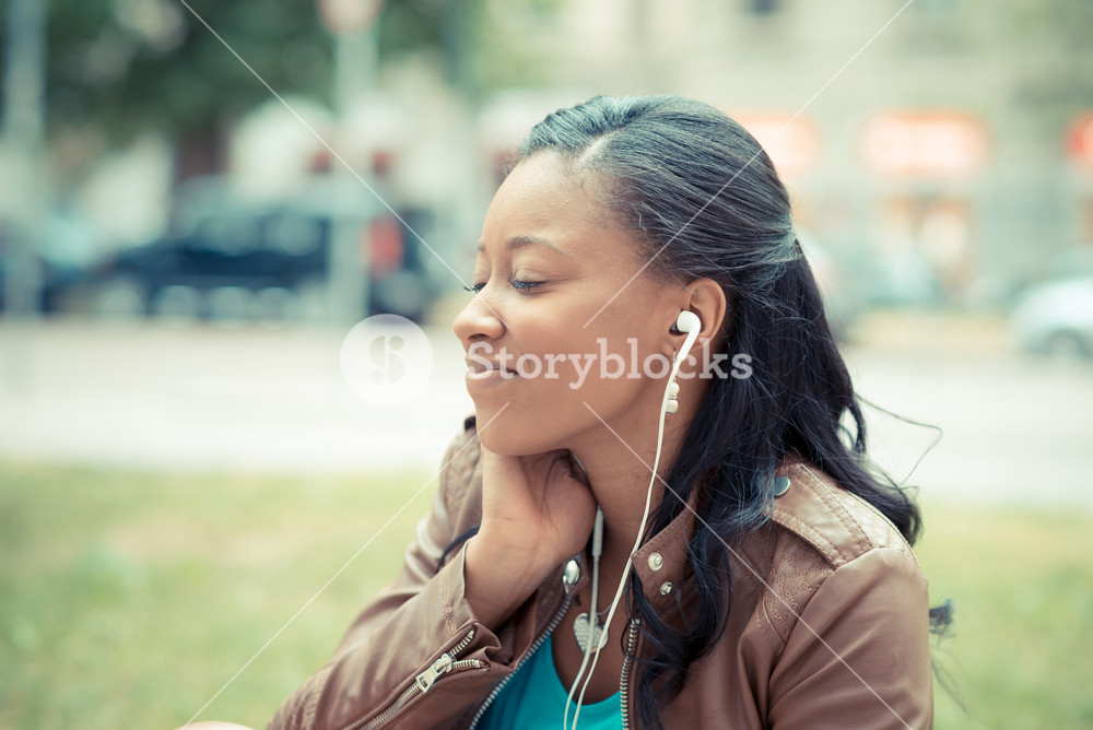 Stylish young woman enjoying music with earphones in the city