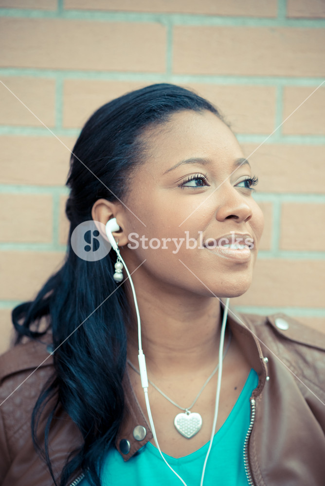 Stylish young woman enjoying music with earphones in the city