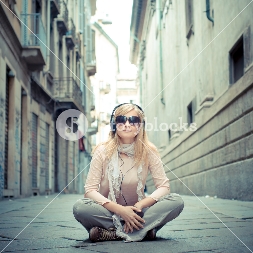 Stylish woman enjoying music in the city