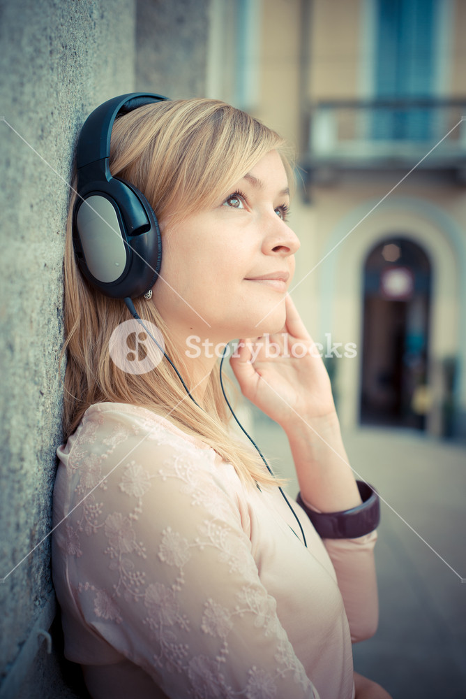 Stylish woman enjoying music in the city
