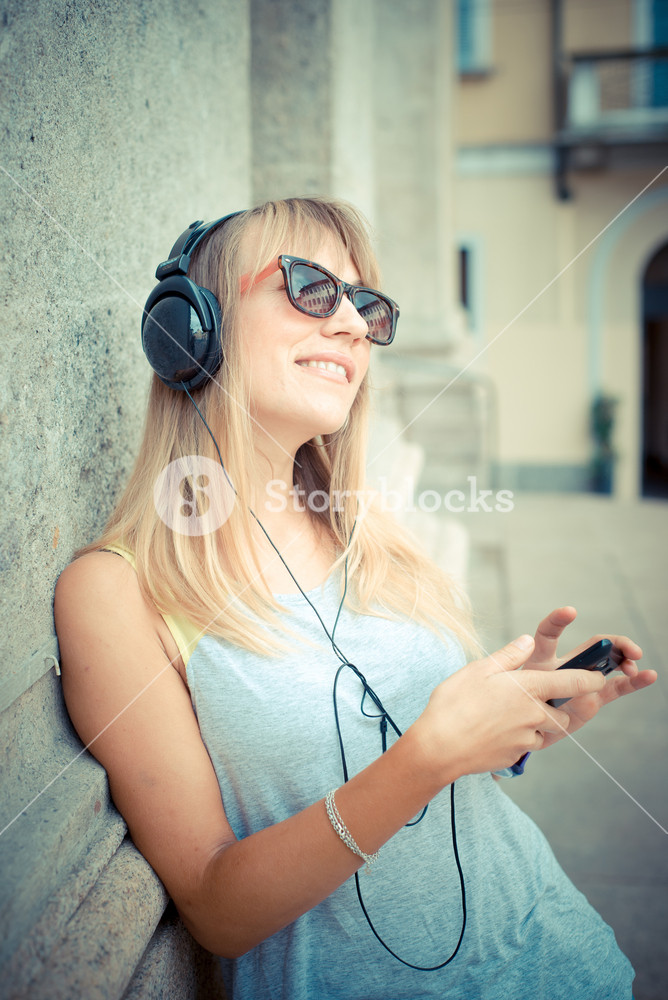 Stylish woman enjoying music in the city