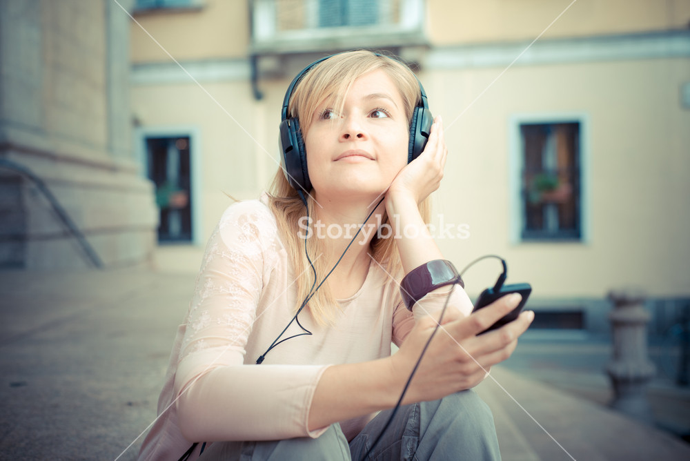 Stylish woman enjoying music in the city