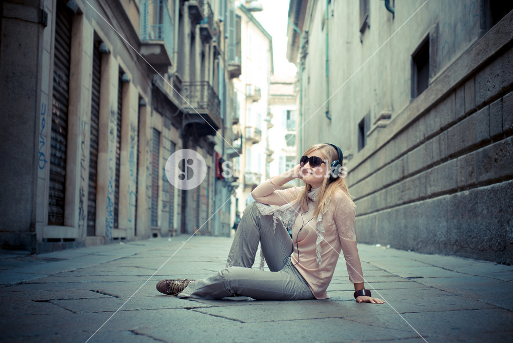 Stylish woman enjoying music in the city