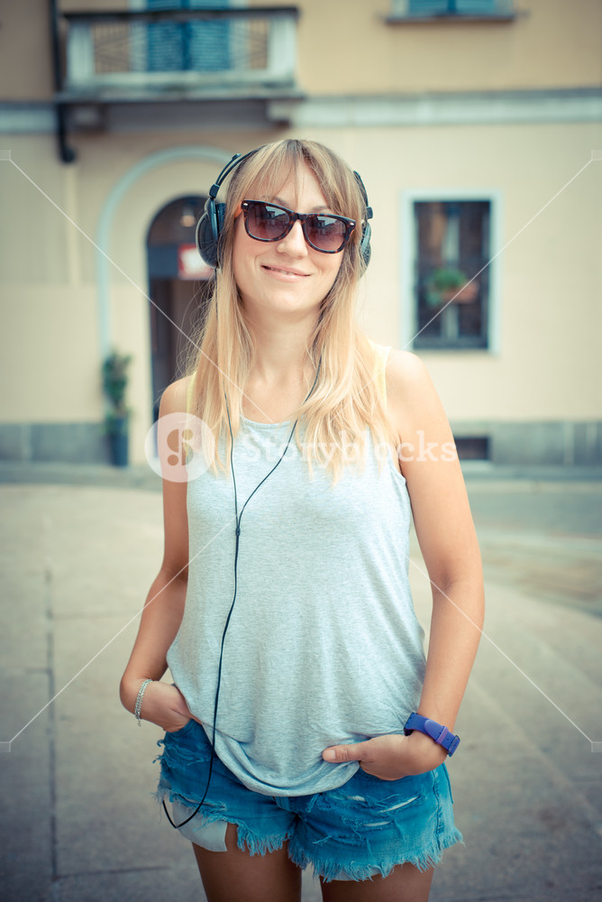 Stylish woman enjoying music in the city