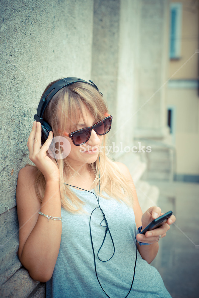 Stylish woman enjoying music in the city