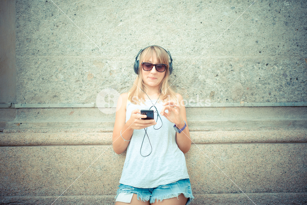 Stylish woman enjoying music in the city