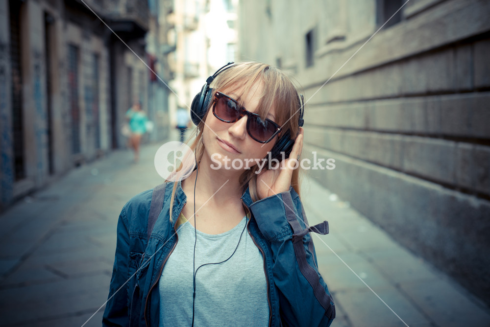Stylish woman enjoying music in the city