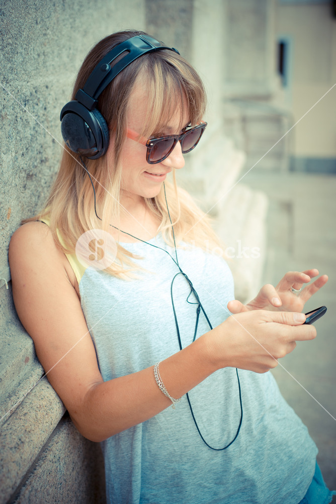 Stylish woman enjoying music in the city