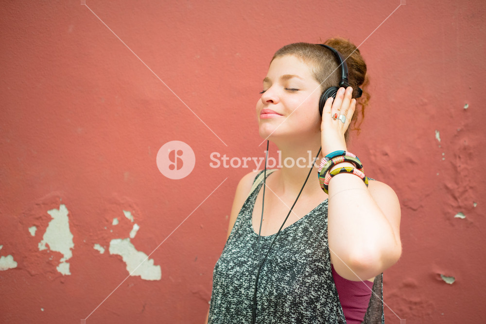 Stylish young woman enjoying music in the city