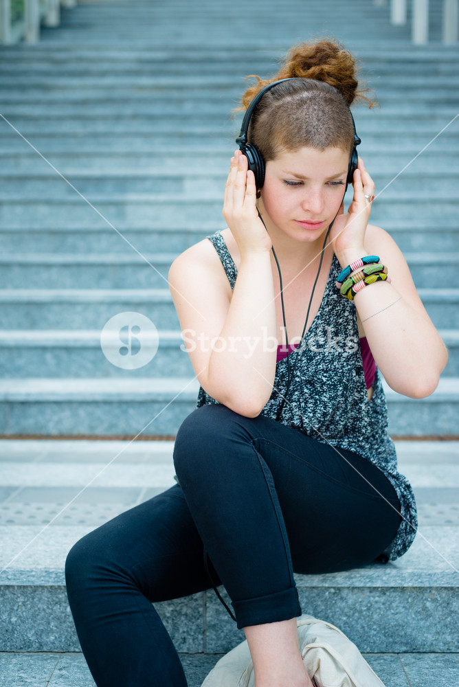 Stylish young woman enjoying music in the city