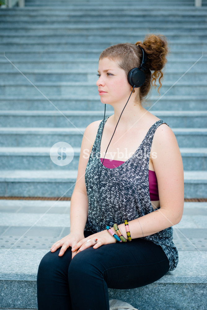Stylish young woman enjoying music in the city