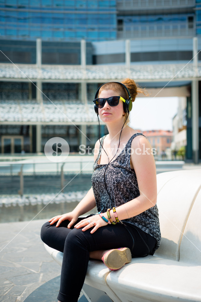 Stylish young woman enjoying music in the city
