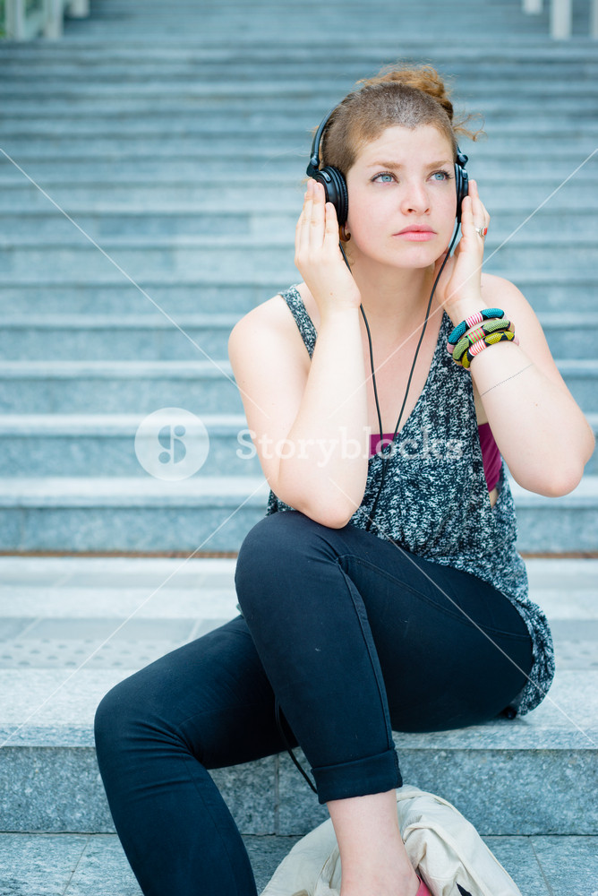 Stylish young woman enjoying music in the city