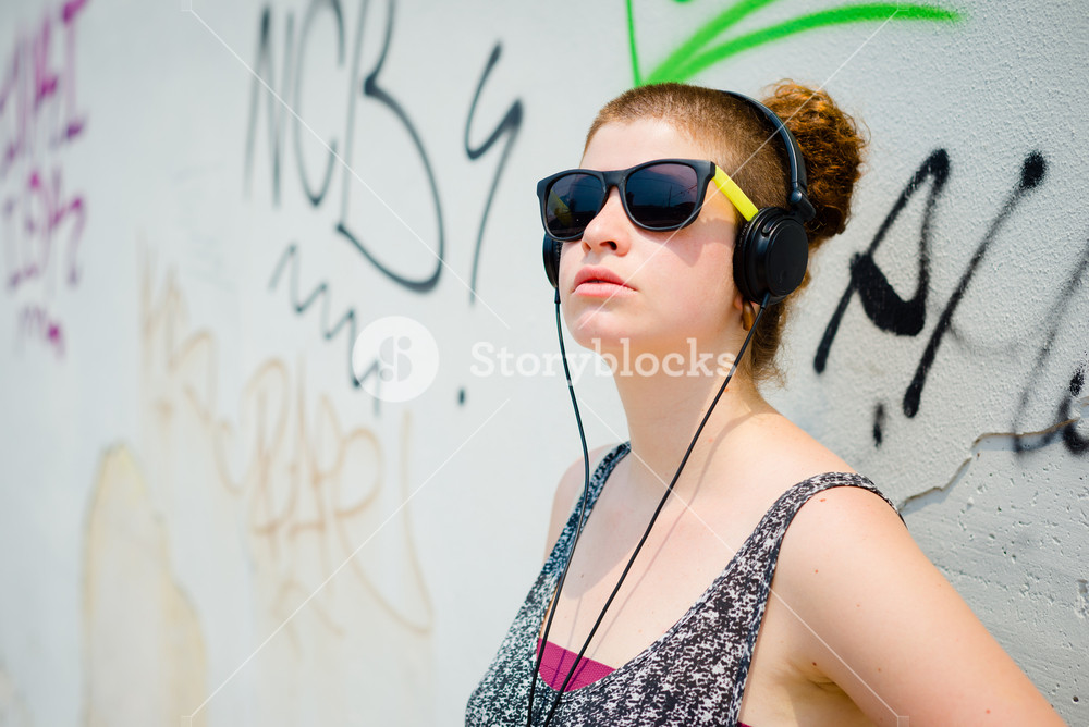 Stylish young woman enjoying music in the city