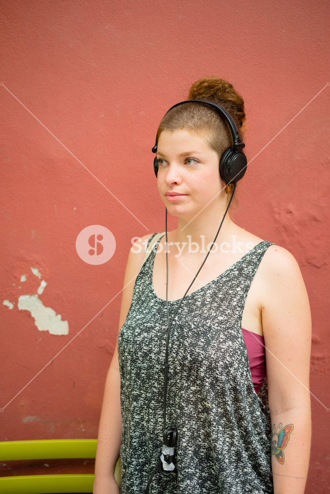 Stylish young woman enjoying music in the city