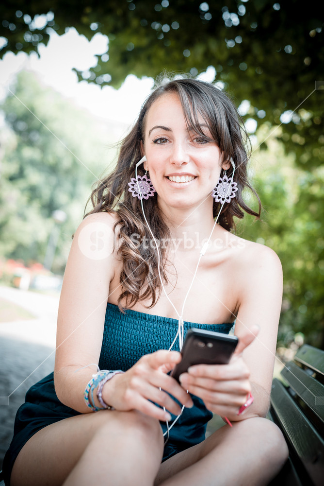 Woman enjoying music with phone player in the city