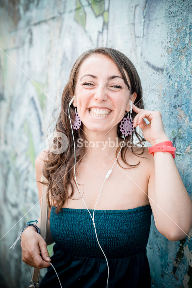 Woman enjoying music with phone player in the city